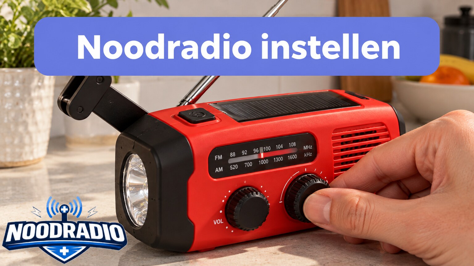 Een hand bedient de afstemknop van een noodradio op een aanrecht