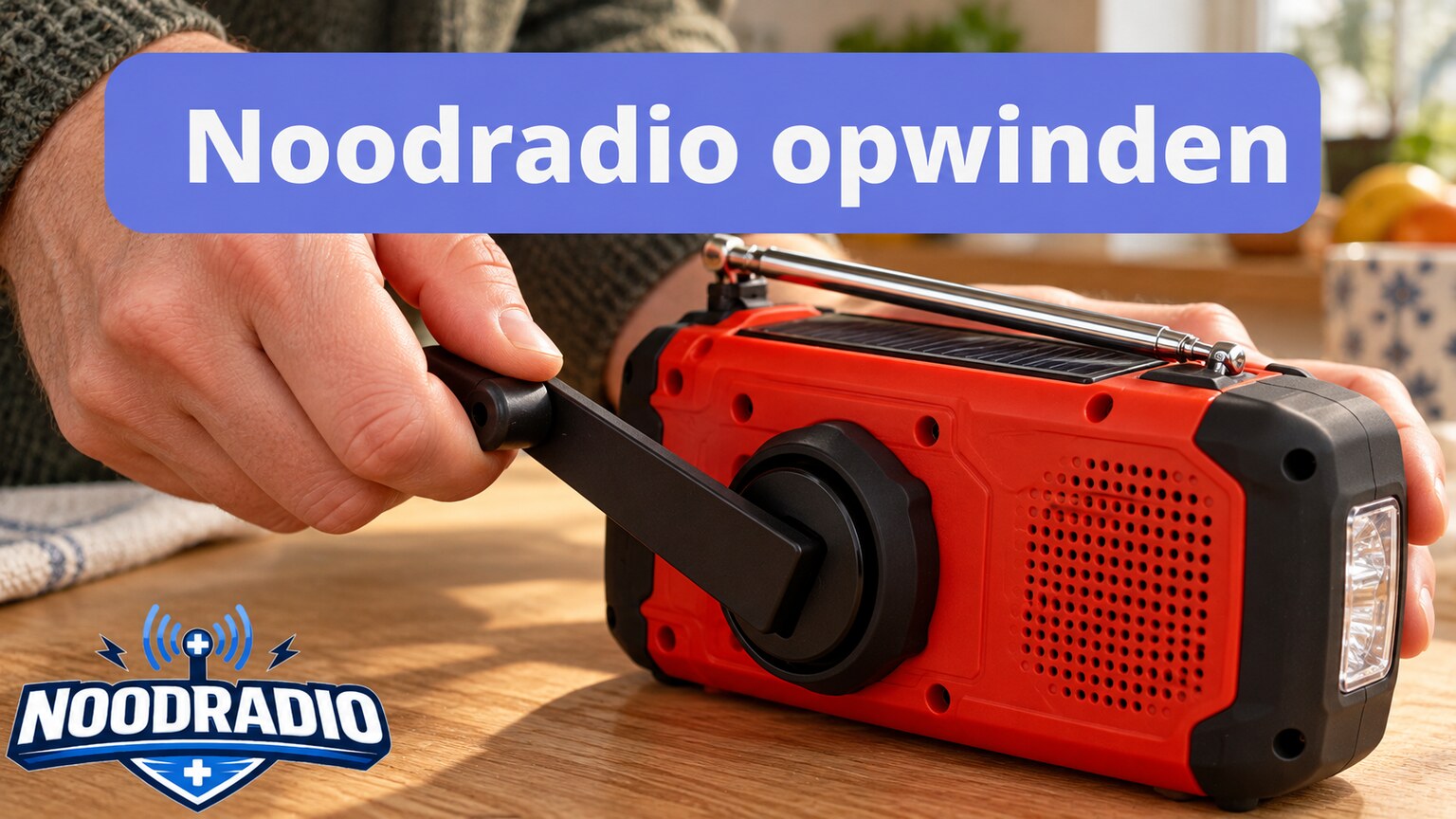 Hand die de uitgeklapte slinger van een compacte noodradio draait